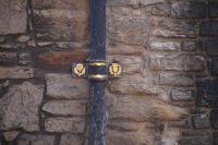 Tudorrose und schottische Distel. Regenrohrklammern in Edinburgh Castle
