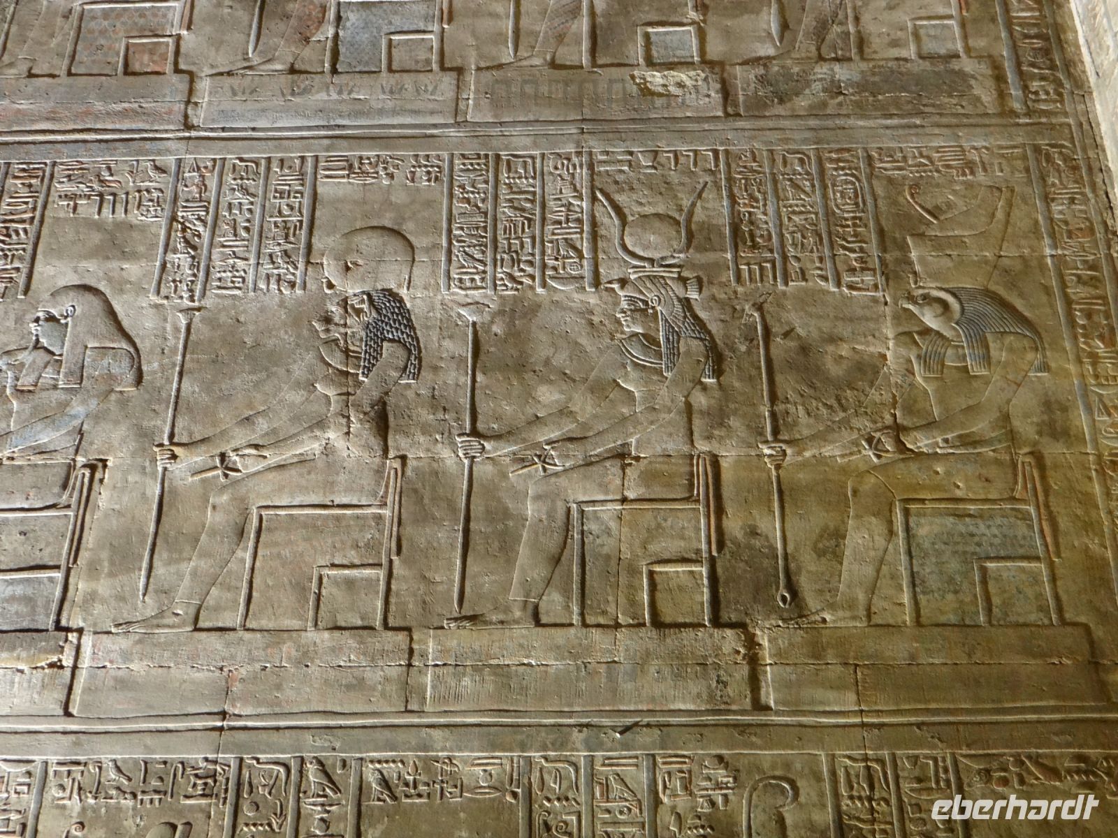 Edfu, Horus-Tempel, die Sitzhaltung wirkt kopiert, doch jeder Kopf mit den Machtsymbolen ist in feiner Arbeit anders gestaltet.