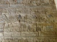 Edfu, Horus-Tempel, die Sitzhaltung wirkt kopiert, doch jeder Kopf mit den Machtsymbolen ist in feiner Arbeit anders gestaltet.