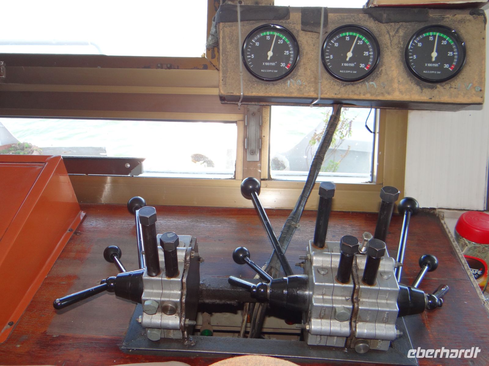 Nilkreuzfahrt, Besuch beim Kapitän. Die Armatur ist überschaubar und das Steuer wird mit den Knien festgehalten. 