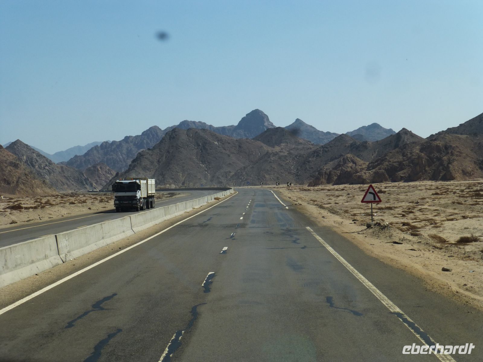 Auf dem Weg nach Hurgadha, die Straße scheint sich im Gebirge zu verlieren. Das Verkehrsschild zeigt die Richtung an.