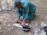 Spaziergang Kaffee-Plantage - Kaffee wird mit einer Glasflasche gemahlen