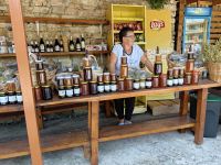 Eine Bäuerin verkauft an der Straße Honig, Schnaps und Propolis