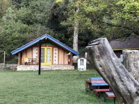 Vor dem Hotel im Llogora Nationalpark stehen gemütliche Hütten