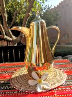 Arabische Kaffeekanne mit der Blüte des Frangipanibaumes im Vorderbaumes