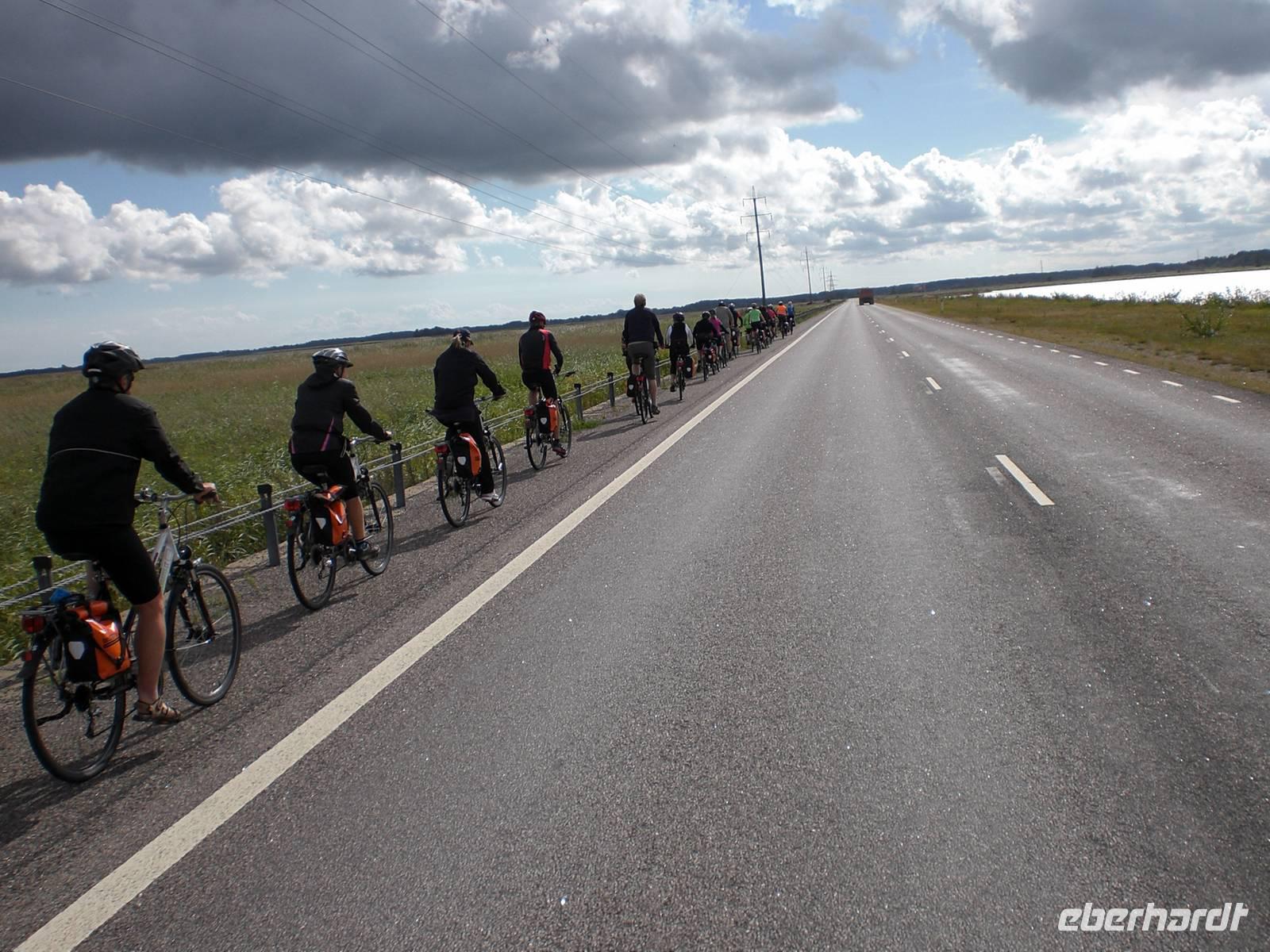 Radreisegäste während der Fahrt auf dem Damm