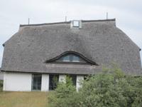 Reetdachhaus auf der Insel Hiddensee - das Dach neigt sich dem Meer zu zum Schutz vor Stürmen
