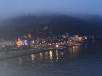 Blick von der Moselbrücke auf das abendliche Traben Trarbach, im Hintergrund im Nebel die Grevenburg