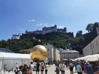 Die Sphaera oder der Mann auf der Kugel von Stefan Balkenhof und das Wahrzeichen Salzburgs, die Festung Hohensalzburg