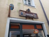  altes Ladenschild über modernem Geschäft