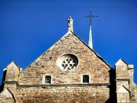 Maria mit dem Kind auf der Abteikirche in Val Dieu und strahlend blauer Winterhimmel
