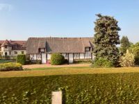 Fachwerk und Reet: Tradition in der Normandie.