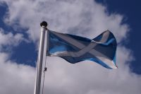 Das schottische Andreaskreuz weht weiß auf blau über Urquhart Castle 