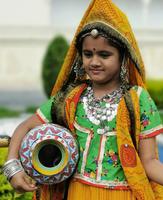 Kleine Inderin, die ein Kostüm für ein Foto angezogen hat, Udaipur