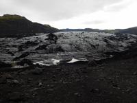 Noch heute bedeckt Asche von Vulkanausbrüchen den Solheimajökull. Weil diese das Abschmelzen beschleunigt, wird sie zu großen Haufen zusammengekehrt.