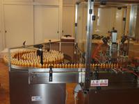 Hier sehen Sie die Abfüllanlage für Parfums. Das Parfum wird links in die kleinen goldenen Behältnisse gespritzt.