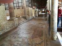 Langer Gang mit Mosaiken belegt.