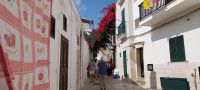 Bunte Gasse in Polignano a Mare mit Gästen Apulien @Anette Rietz
