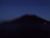 Blick vom schwankenden Schiff auf den nächtlichen Vulkan