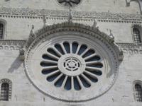 Sie ist von sieben Figuren umgeben. 