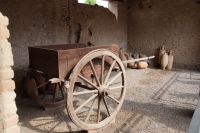 Haus des Menander, Wirtschaftsbereich: Nach Funden der Eisenteile rekonstruierter Wagen im Haus eines Händlers, im Hintergrund Schiffsamphoren