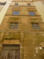 Eine gotische Hausfassade, zwei Fenster breit und sehr hoch. 