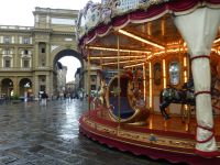 Das Pferdekarussell auf der Piazza della Repubblica Firenze leuchtet an diesem Tag durch den Regen.