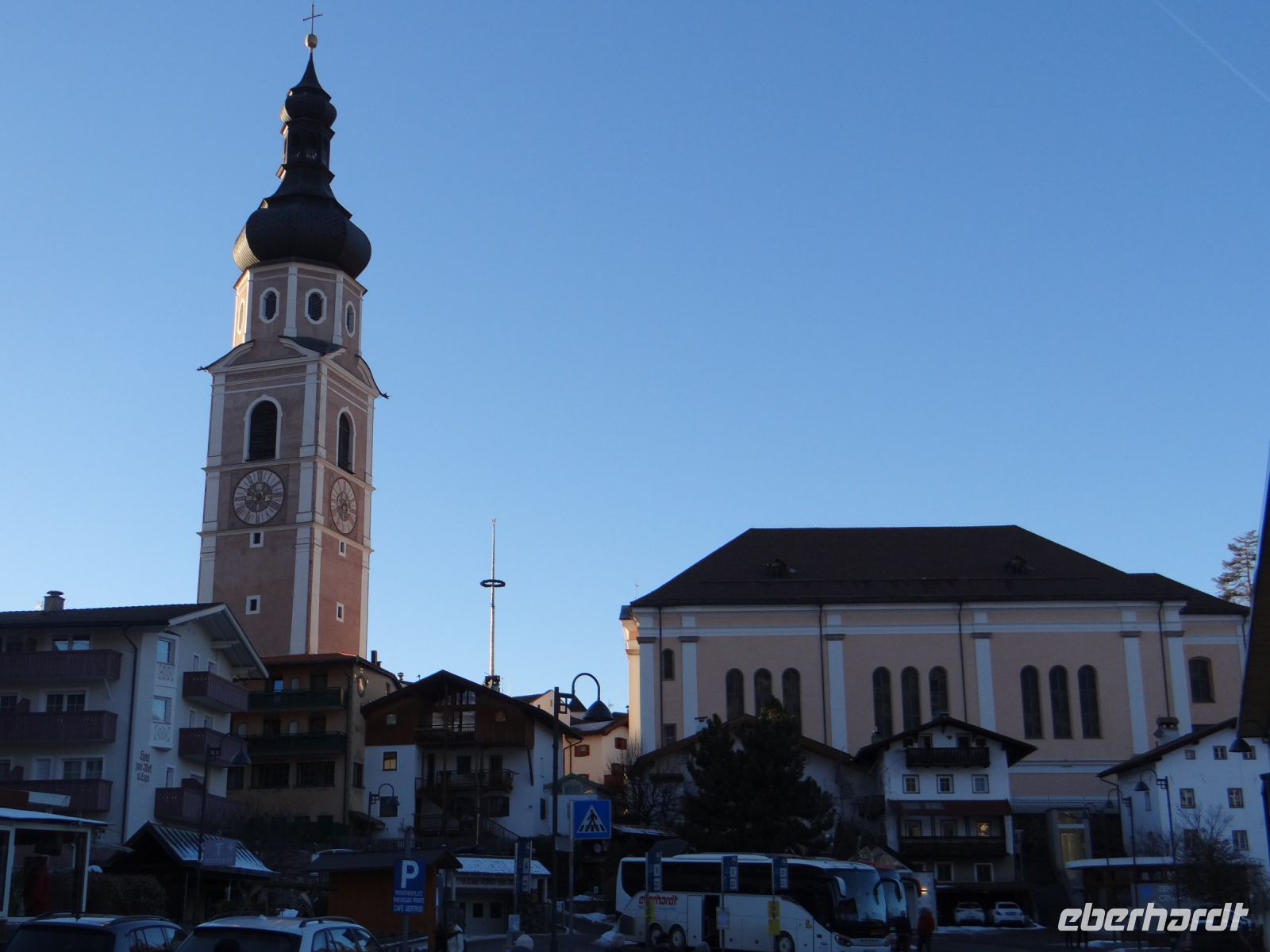 Kastelruth, Glockenturm und Kirche stehen getrennt voneinander, im Zwischenraum hat der Weihnachtsmarkt Platz