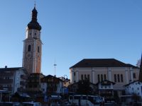 Kastelruth, Glockenturm und Kirche stehen getrennt voneinander, im Zwischenraum hat der Weihnachtsmarkt Platz