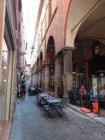 Bologna, Tische unter und vor den Arkaden. Jeder Platz ist schön zum Sitzen und Genießen.