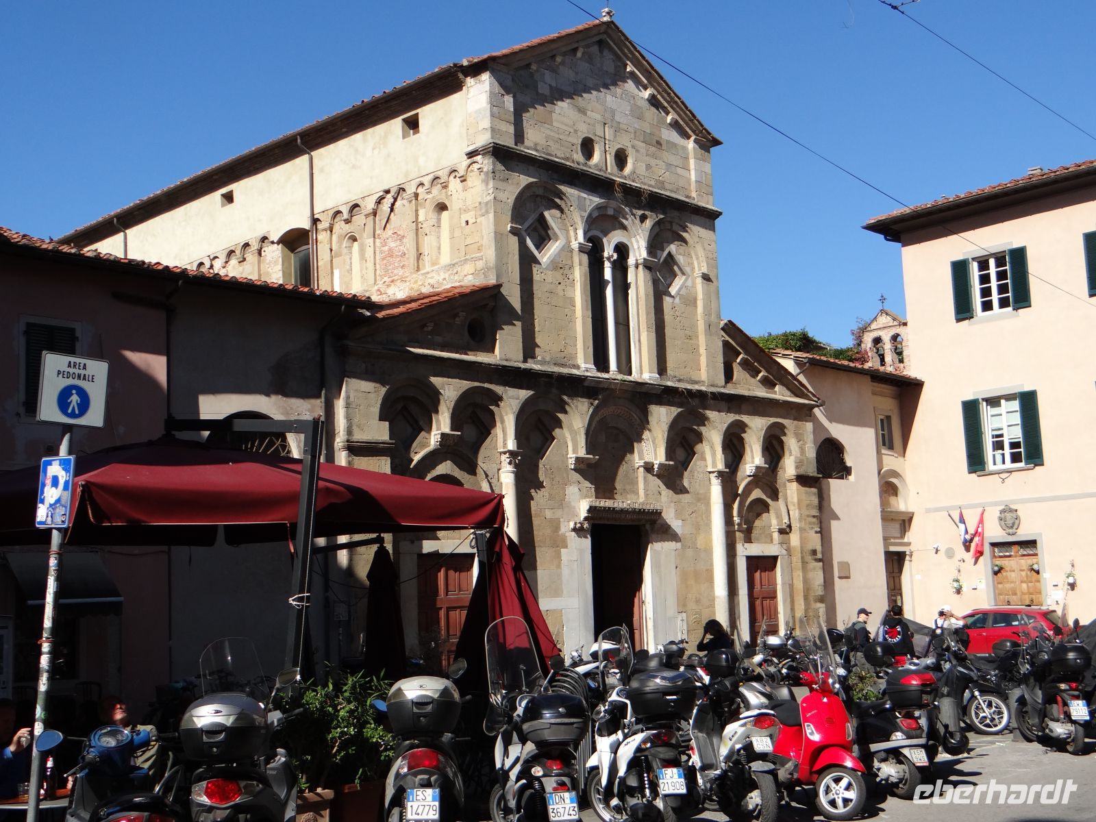 Pisa, der Vorplatz von San Frediano: ein typisches Bild mit Kirche, Café und Vespas.