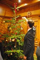 Der Hausherr des Hotel zündet die Kerzen des Weihnachtsbaums an 
