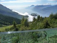 Unter uns, leicht neblig, der See.