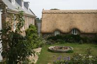 Typisches Cottage auf Guernsey mit Cider-Presse im Vordergrund