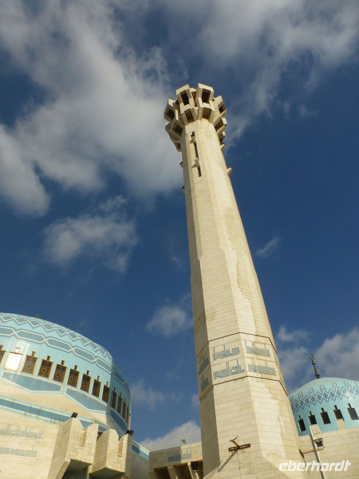 Ein leuchtturmartiges Minarett, das in der Nacht beleuchtet ist wie eine Konfirmationskerze.