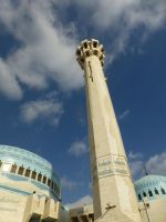 Ein leuchtturmartiges Minarett, das in der Nacht beleuchtet ist wie eine Konfirmationskerze.