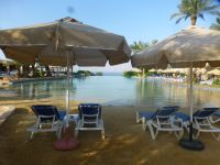 Der Pool ist bereit für seine Gäste, der Poolgrund gereinigt, der Sand gehakt, die Liegen ausgerichtet und die Sonnenschirme aufgespannt. 