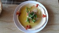Hummus mit Olivenöl und etwas Salat, dazu Brot