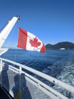 Am Heck die Kanadische Flagge und am Horizont ein Schiff - Kanada
