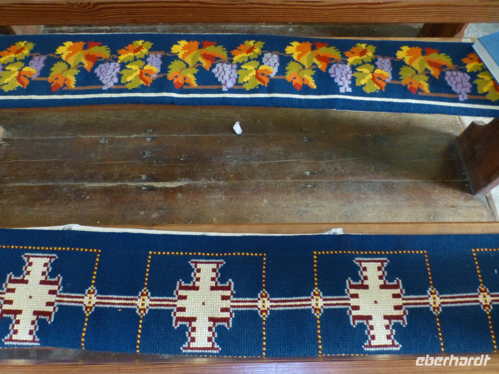 Die Sitzbänke der Kirche sind mit den 40 verschiedenen Wappen der Pachtgrundstücke bestickt. So hat jeder seinen festen Platz. 