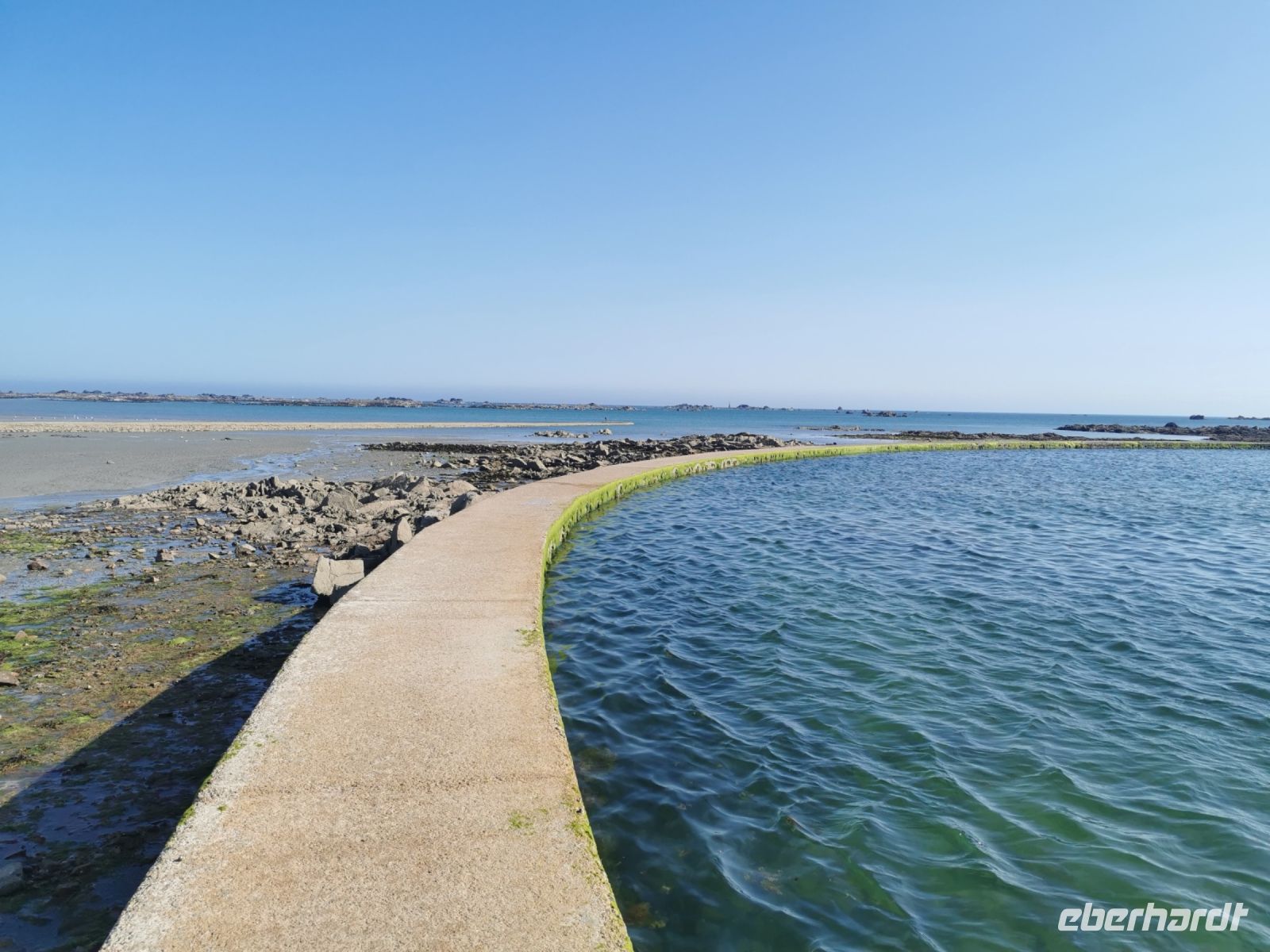 Dieser feste Ring hält das Wasser bei Ebbe zurück und erlaubt somit Baden rund um die Uhr.