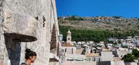 146 Dubrovnik, Kristina vor alter Schiffshalterung am Hafen mit Turm der Dominikanerkirche und Berg Srd
