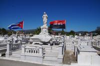 Gräber von Veteranen des Befreiungskrieges von der Batista-Diktatur werden mit der Nationalfahne und der der Bewegung des 26. Juli markiert - dabei ist das Bekenntnis zum Christentum offenbar kein Widerspruch