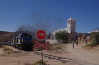 Aus: Kirche, Bahnübergang und fahrender Zug
