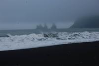 Felsnadeln und schwarzer Sandstrand bei Vik im mystischen Nebel