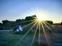 Die Sonne geht hinter der Kirche des guten Schafhirten am Lake Tekapo unter 