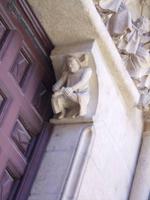 Der Pilger zieht sich mit schmerzverzerrtem Gesicht einen Dorn aus dem Schuh. Kathedrale von Burgos