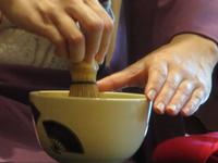Traditionelle Teezeremonie - Matcha-Tee wird schaumig geschlagen