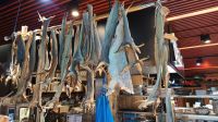 Bergen - Fischmarkt - Tarditioneller Stockfisch und ein Klippfisch (Bildmitte - dritter von Rechts)