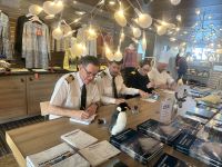 Der Kapitän signiert Bücher